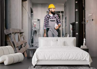 A worker with toolbox arrives at his workplace, unfinished building. Wall mural