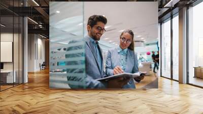 Business couple at tech store looking at catalog. Wall mural