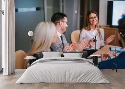 Cheerful businesspeople applauding a in a meeting at boardroom. Wall mural