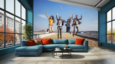 Four excited happy business people jumping on rooftop and cheering for success. Wall mural