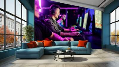 Happy gamer playing favorite game at gaming room. Wall mural