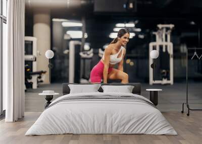 Happy strong sportswoman in trendy sportswear doing lunges with weight plates in a gym. Wall mural