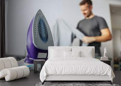 Photo frame of an Isolated laundry iron with a metal warming plate on the ironing board on the background copy space. A man who does housework, a good husband, or a single man. Modern lifestyle Wall mural