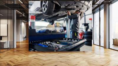 Selective focus on a tools in toolbox at mechanic's shop with mechanic repairing the car in blurry background. Wall mural