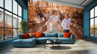 Small group of people running in woods. Wall mural