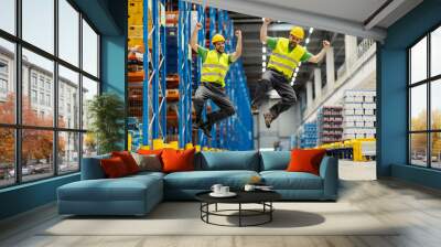 Two warehouse workers jumping and celebrating success. Wall mural