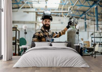 Worker with a welding machine at workshop. Wall mural