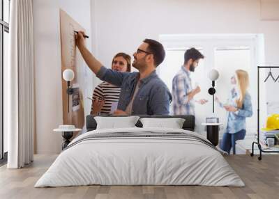 Young developers are brainstorming new algorithms how to make their software better optimized for users , while writing them down on a brownboard. Wall mural