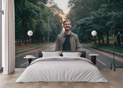  happy man standing on road in front of trees Wall mural