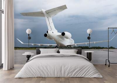 White luxury executive aircraft on the airport apron on a cloudy day Wall mural