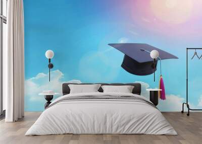 A black graduation cap with a purple and yellow tassel is flying in the sky. Concept of accomplishment and achievement Wall mural