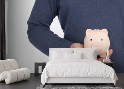 Hand of man holding a pink piggy bank isolated on white background, saving concept Wall mural