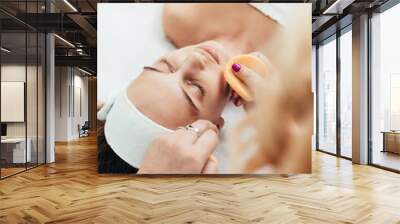 Beautiful and attractive adult woman receiving professional face skin beauty treatment Wall mural