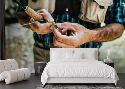 Close up shot of senior fisherman's hands tying a fly for fishing. Fly fishing concept. Wall mural