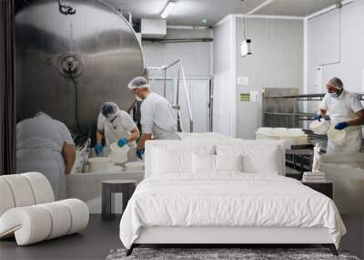 Manual workers in cheese and milk dairy production factory. Traditional European handmade healthy food manufacturing. Wall mural