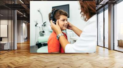 Young boy at medical examination or checkup in otolaryngologist's office Wall mural