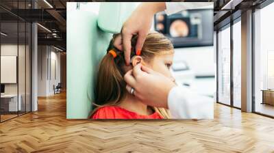 Young girl at medical examination or hearing aid checkup in otolaryngologist's office Wall mural