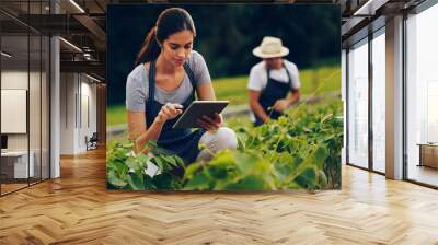 smart farmers use smart technology. shot of a young woman using a digital tablet while working in a  Wall mural