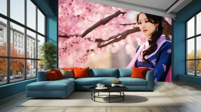 A beautiful Asian woman wearing a traditional Korean hanbok dress stands under a cherry blossom tree Wall mural