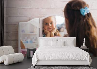 beautiful little caucasian girl looks in the mirror and smiles Wall mural