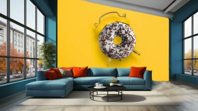 top view flat lay creative art collage donut and alarm clock on a yellow background copy space Wall mural