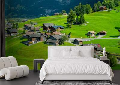 Stunning view of Grindelwald Valley in summer with golden sunshine on green grass. Heavenly beauty village in Switzerland. Wall mural