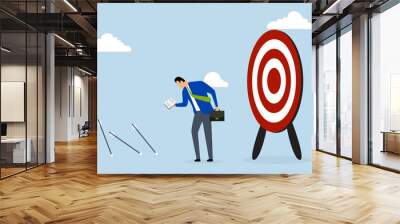 Learn from failure, businessman holding book and looking at missed target, learning mistakes. Wall mural