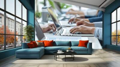 Business team worked with laptops and documents on a desk in the office, with a close up view of hands using a computer for an online meeting or conference call at the work place. Wall mural