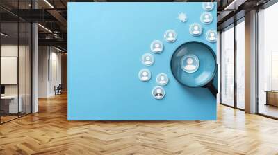 Photo of a magnifying glass over target audience icons on a blue background, showing a customer profile concept for business and marketing planning Wall mural