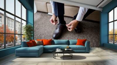 a man ties the laces in his shoes in the morning in the room Wall mural