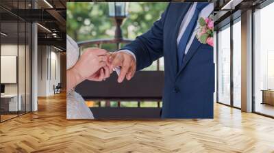 bride and groom wear rings at the ceremony Wall mural