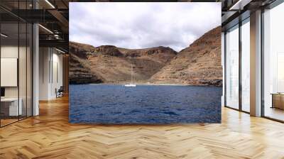 Sailboat and rocky coastline in sea in front of la gomera, Canaries, Spain Wall mural