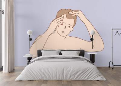 Health, care, frustration, examination, irritation concept. Young frustrated sad upset man guy with alopecia cartoon character looking at mirror examining head. Age problem of hair loss illustration. Wall mural