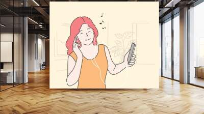 Woman listening to music concept. Young happy smiling girl teenager cartoon character holding mobile phone and enjoys musical songs sound in headphones and having fun. Leisure time and home recreation Wall mural