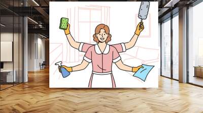 Woman maid is ready to quickly clean apartment, working in multitasking mode thanks to presence of four hands. Girl maid stands in hotel room and holds items to perform high-quality cleaning Wall mural