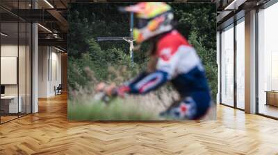 Motorcyclists during the off road race on the first plan and Crucifix in the background. Wall mural