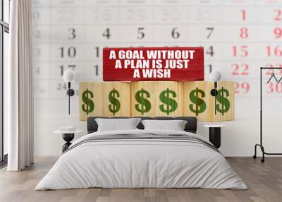 Against the background of the calendar, cubes and a plate with the inscription - A Goal Without a Plan Is Just a Wish Wall mural