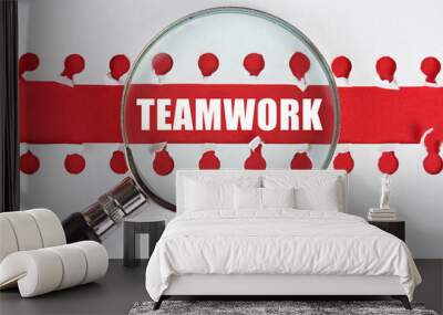 Between two sheets from a notebook on a red stripe with the inscription - Teamwork, there is a magnifying glass Wall mural