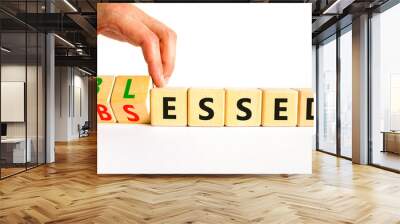 Blessed or obsessed symbol. Businessman turns wooden cubes and changes the concept word Obsessed to Blessed. Beautiful white table white background. Business blessed or obsessed concept. Copy space. Wall mural