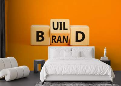 Build your brand symbol. Concept word Build brand on wooden cubes. Beautiful orange table orange background. Business and build your brand concept. Copy space. Wall mural