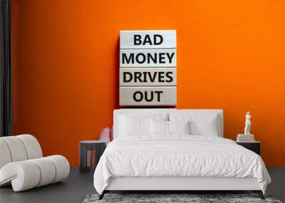 Business concept growth success process. Wood blocks on orange background, copy space. Businessman hand. Words 'bad money drives out good'. Conceptual image of motivation. Wall mural