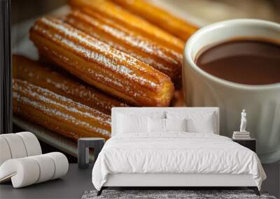 Deliciously golden churros dusted with powdered sugar, served warm alongside a cup of rich dipping chocolate at a cozy cafe Wall mural