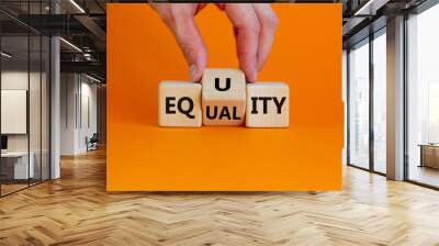 Equality or equity symbol. Businessman turns a cube and changs the word 'equality' to 'equity'. Beautiful orange background. Psychology, business and equality or equity concept. Copy space. Wall mural