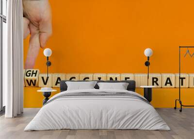 High or low vaccine rate symbol. Doctor turns cubes, changes words 'low vaccine rate' to 'high vaccine rate'. Beautiful orange background, copy space. Medical, covid-19 pandemic vaccine rate concept. Wall mural