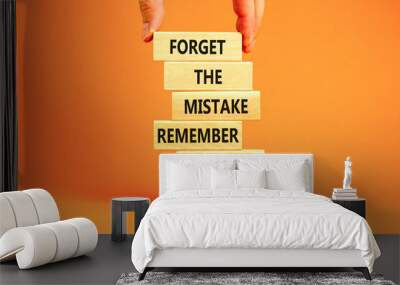 Lesson from mistake symbol. Concept words Forget the mistake remember the lesson on wooden blocks on a beautiful orange table orange background. Businessman hand. Business lesson from mistake concept. Wall mural