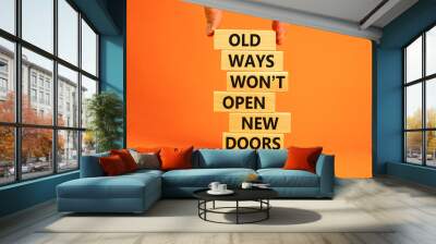 Old ways do not open new doors symbol. Wooden blocks with words 'Old ways do not open new doors'. Businessman hand. Beautiful orange background. Business, popular quotation concept. Copy space. Wall mural