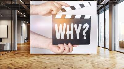 On a white background, a man holds a clapperboard in his hands on which it is written - WHY Wall mural