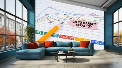 On business charts there is a pencil and an arrow sticker with the inscription - Go to market strategy Wall mural