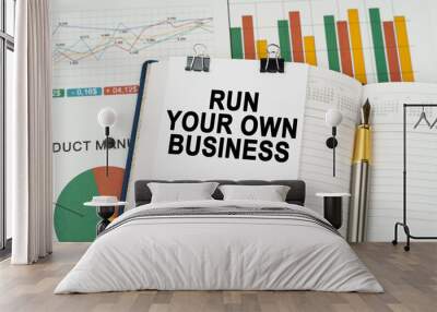 On the business charts is a notepad with the inscription - Run Your Own Business Wall mural