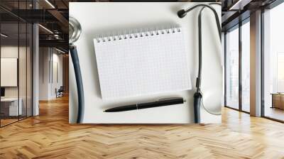 Stethoscope and notebook with pen isolated on white background. Wall mural